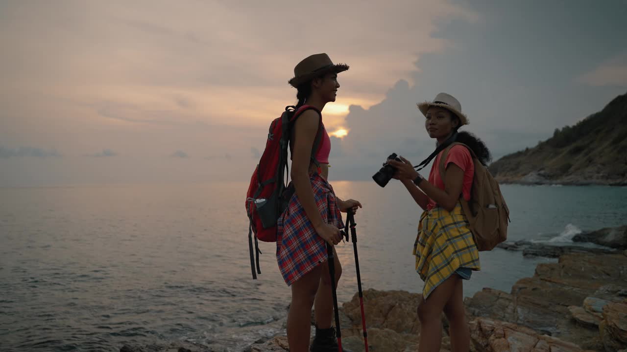 两个爱冒险的女孩用相机拍照，记录她们的冒险旅行记忆;成功、冒险、团队合作、放松、自然的概念。视频素材