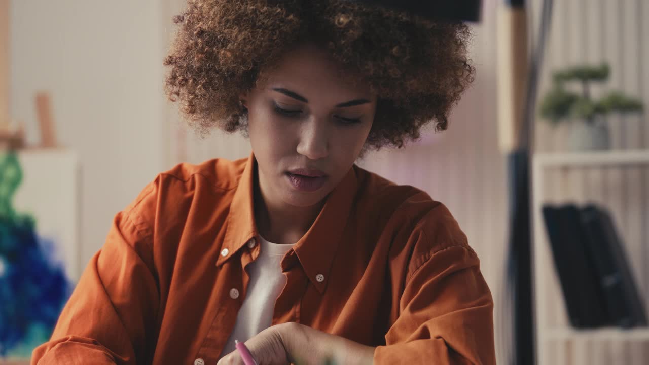 年轻的非裔美国女性在办公室工作时做笔记，设计师视频下载