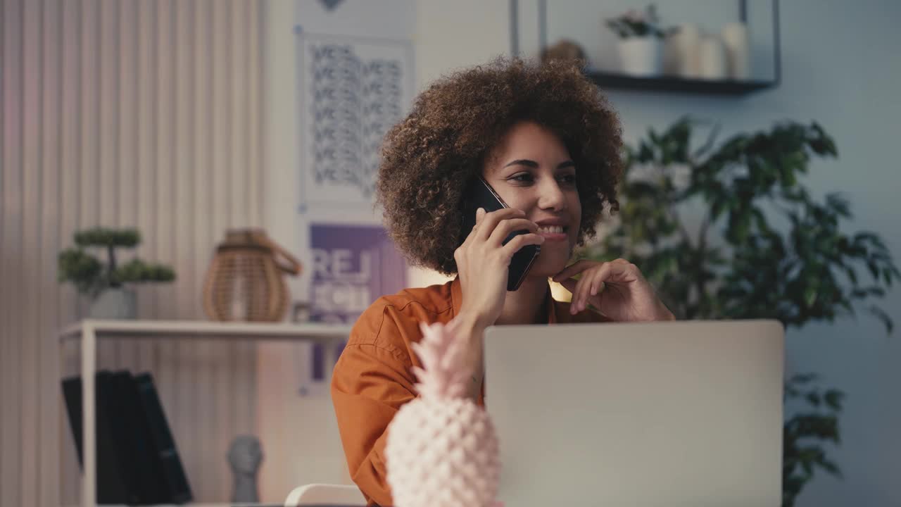 面带微笑的女平面设计师在电话中与客户交谈，看着草图视频下载