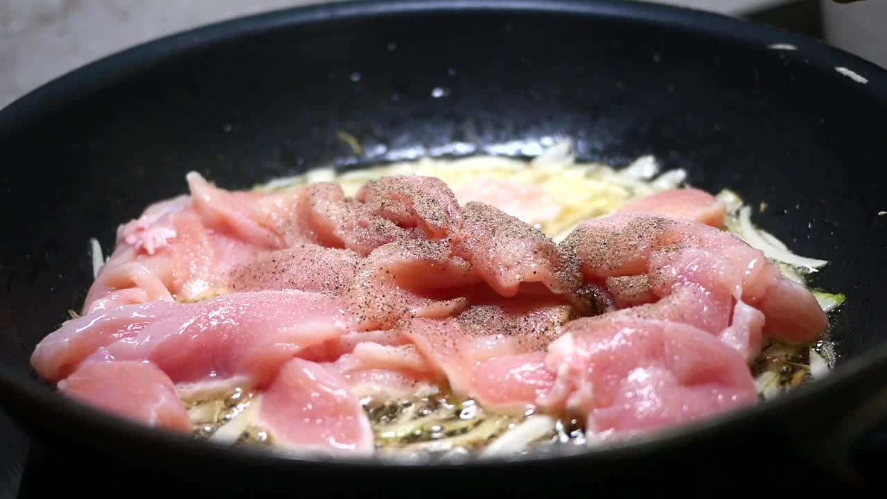 在平底锅里用各种调味料烹饪鸡胸肉，做一顿美味的大餐视频素材