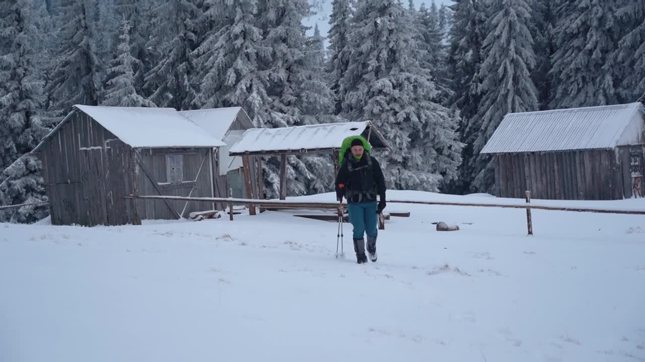 冬天背着背包徒步旅行。在山上的雪小屋附近。乌克兰喀尔巴阡山脉的冬季徒步旅行视频素材