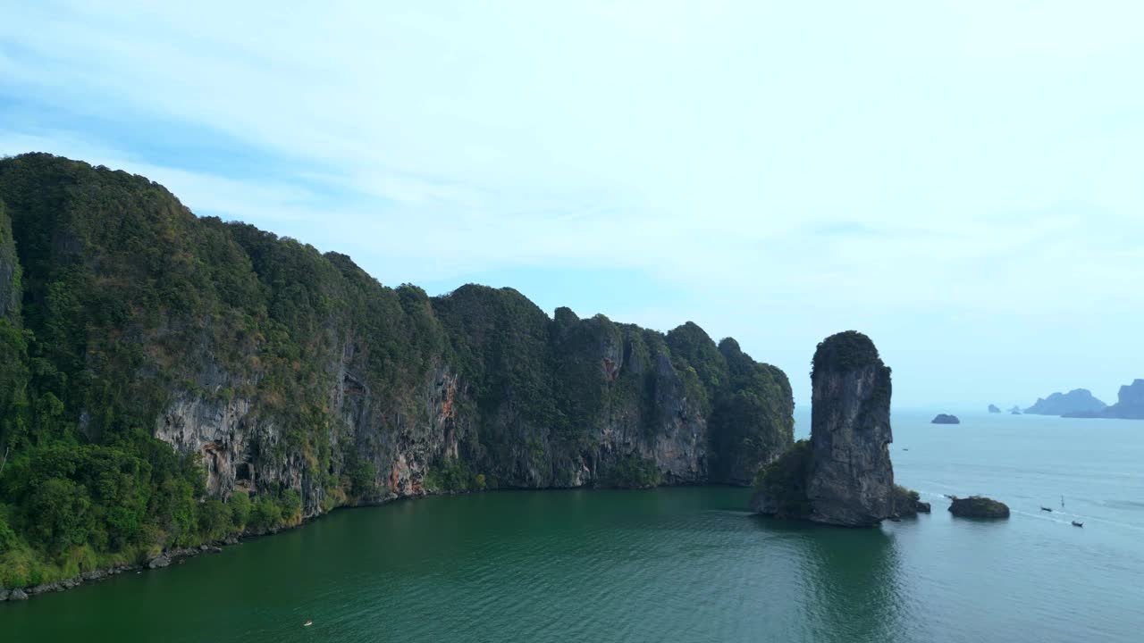 一个幽静的海湾，绿松石般的水，周围是高耸的悬崖，覆盖着郁郁葱葱的绿色植被。壮观的鸟瞰图飞行多莉右无人机视频素材