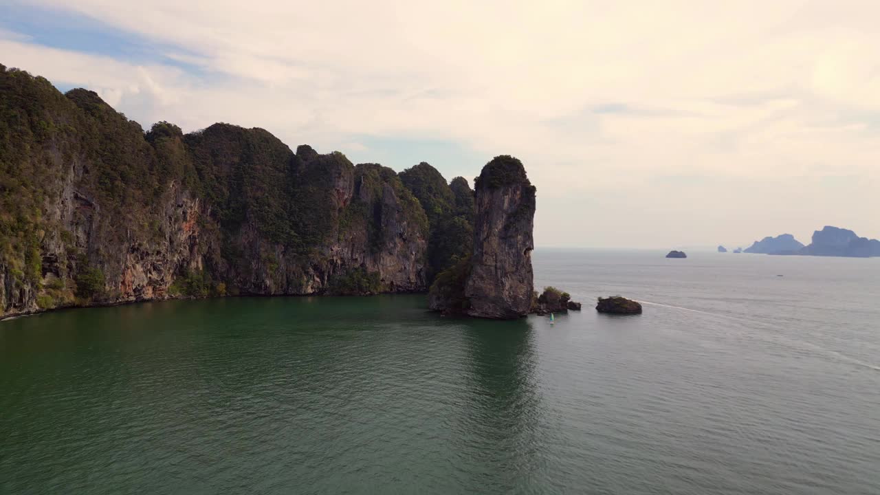 一个幽静的海湾，绿松石般的水，周围是高耸的悬崖，覆盖着郁郁葱葱的绿色植被。伟大的鸟瞰图飞行，飞越，飞越无人机视频素材