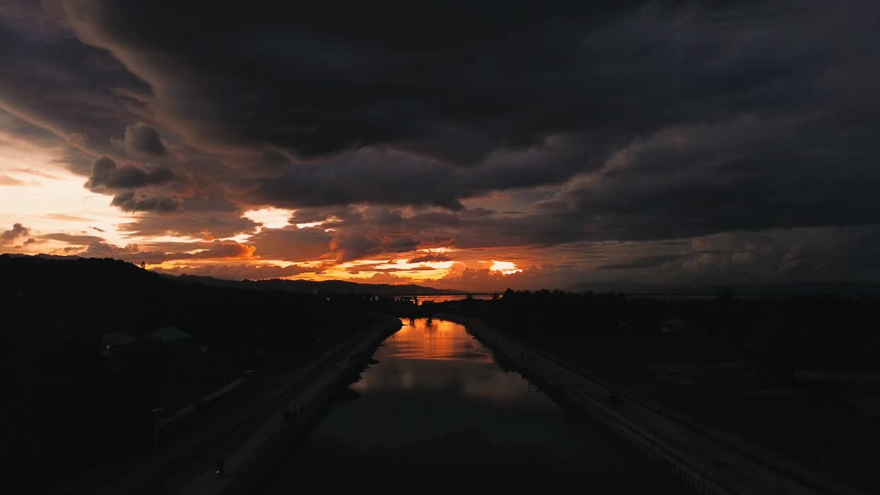 以日落为背景的河流鸟瞰图。戏剧性的天空视频素材