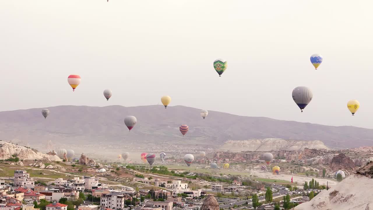 许多热气球飞过土耳其的Göreme市。Goreme、土耳其视频下载