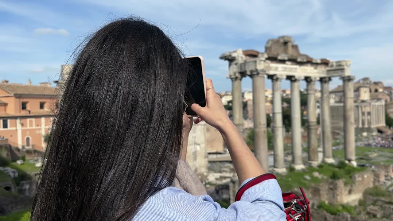 年轻迷人的黑发女子在意大利罗马观光旅游时在罗马广场拍照视频下载