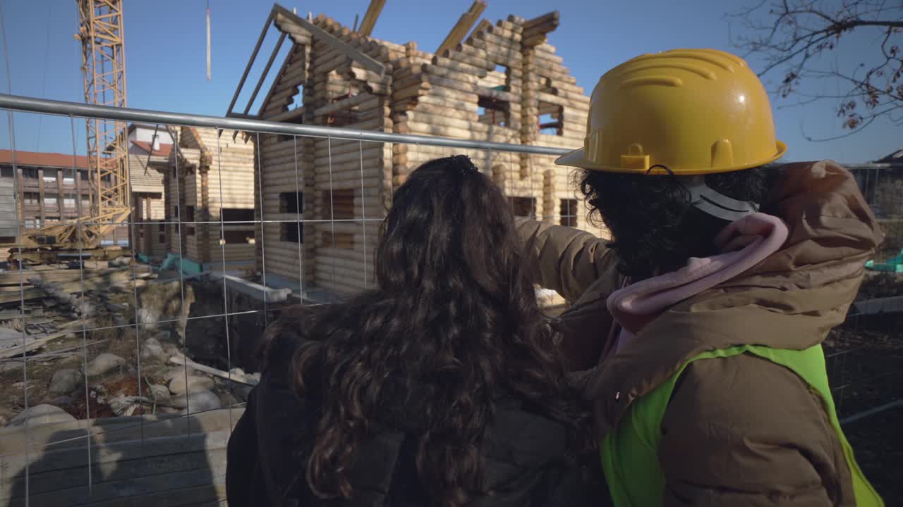 女房主客户在她的新木屋的建筑工地与建筑师或工程师咨询蓝图视频素材