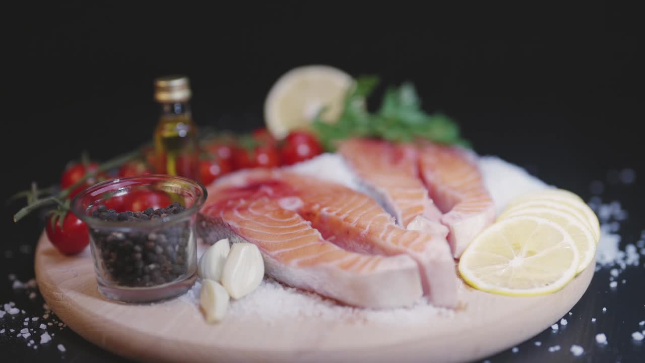 将鲜鲑鱼与西红柿、柠檬和大蒜搭配在一起布置构图视频素材