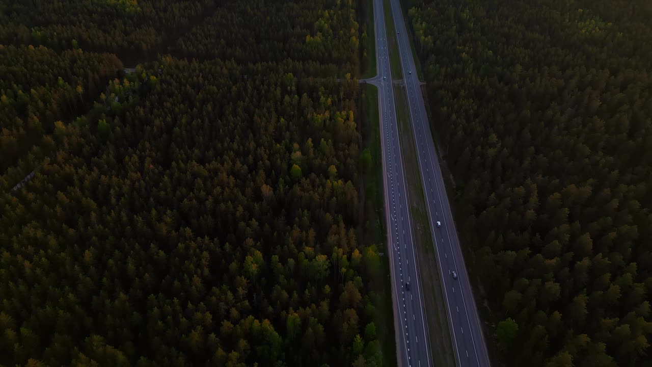 日落时的森林和高速公路鸟瞰图，实时展示自然美景和基础设施视频素材