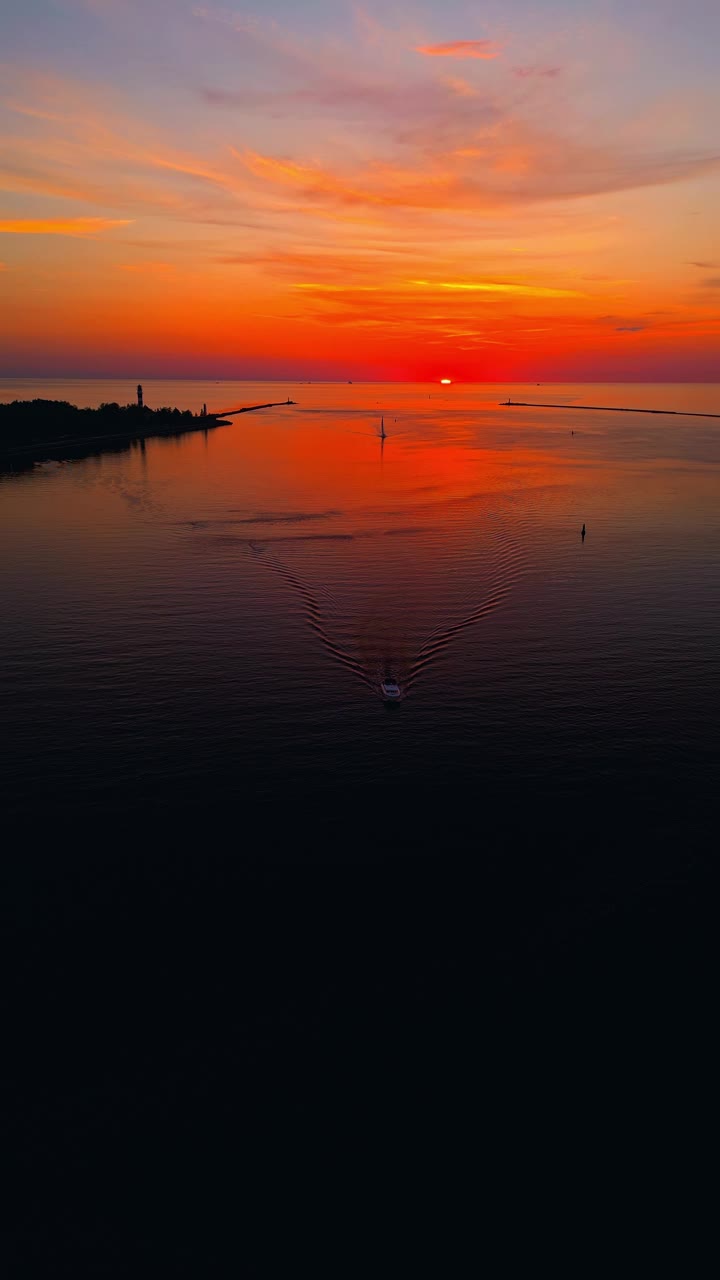 在宁静的海洋上，令人叹为观止的彩色日落鸟瞰图，在视频中突出了自然的宁静之美视频素材