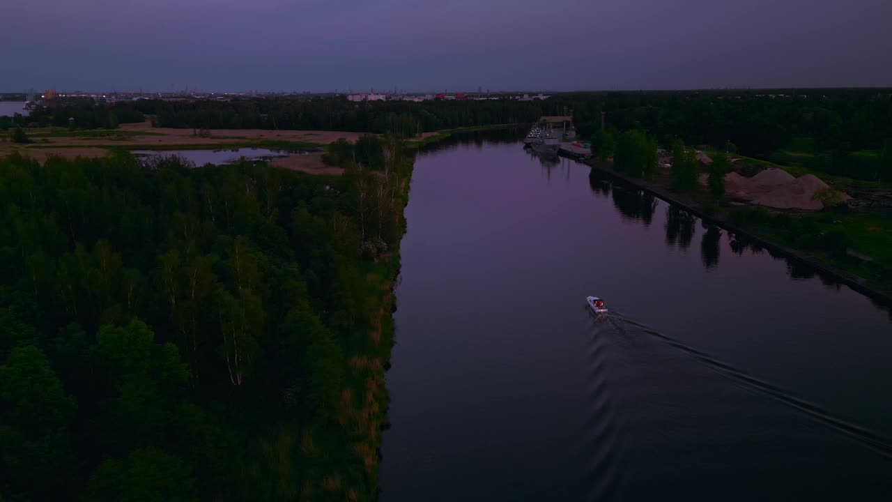 黄昏时分，一艘船沿着宁静的河流平静地航行，鸟瞰图捕捉到了平静的气氛视频素材