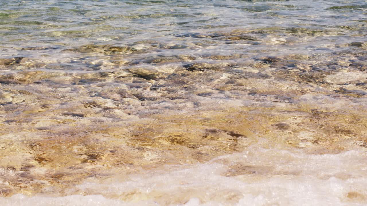 在希腊的海滩上，海浪拍打着鹅卵石的运动视频下载