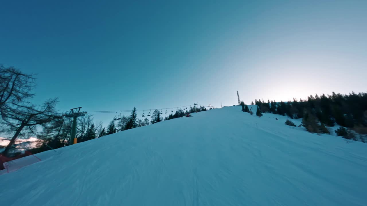 日出时爬升雪山的滑雪缆车，山坡上树木成排视频素材