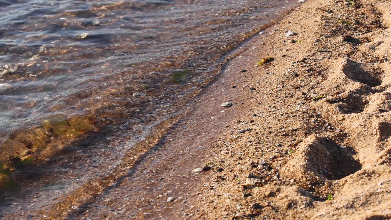 海浪冲刷着沙滩上的脚印视频素材