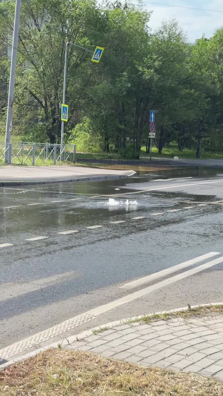 柏油路下的管道漏了，城市街道上的水像间歇泉一样涌出。沥青上的水导致公用事业事故视频下载