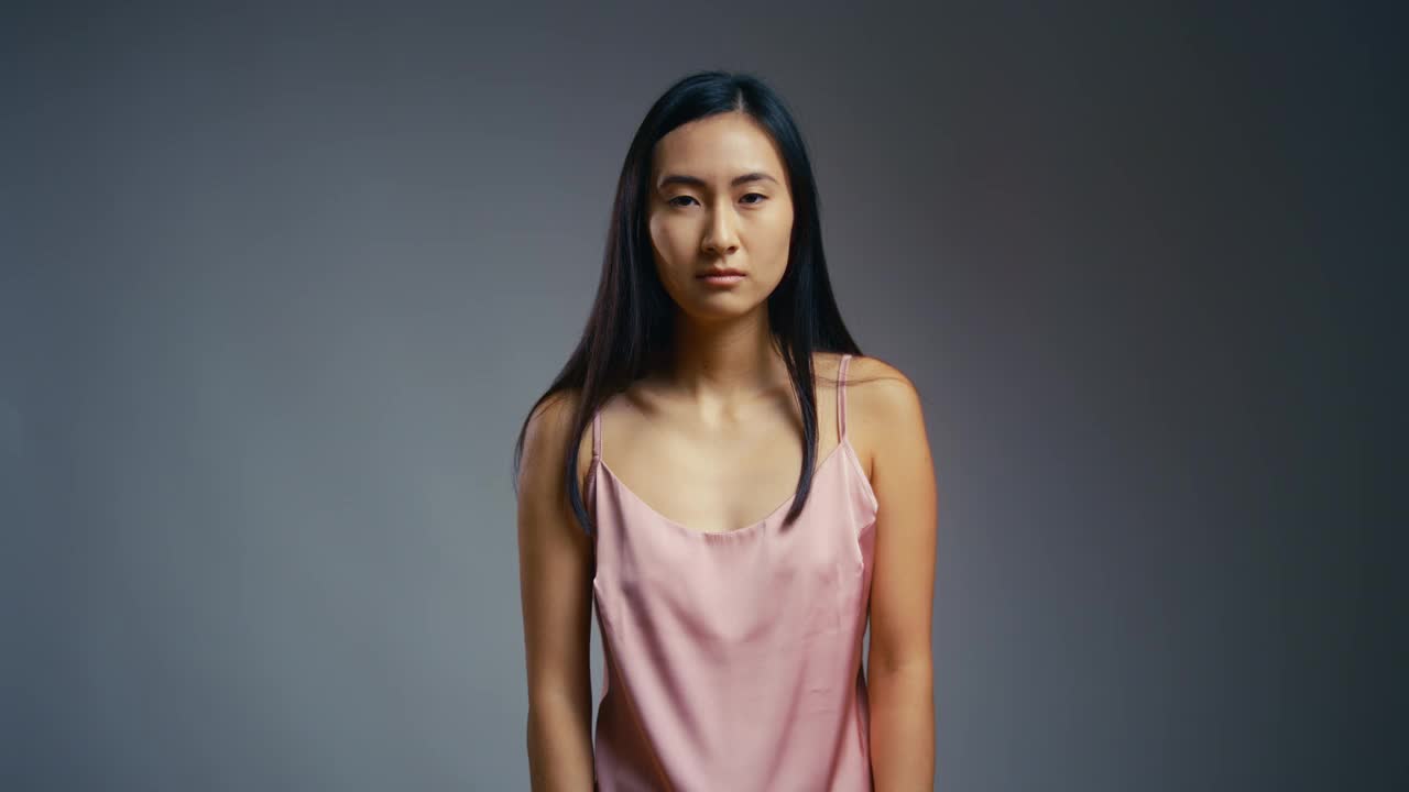 一名年轻的亚洲女性正在检查自己的皮肤，她对自己的面部护肤程序很不满意视频下载