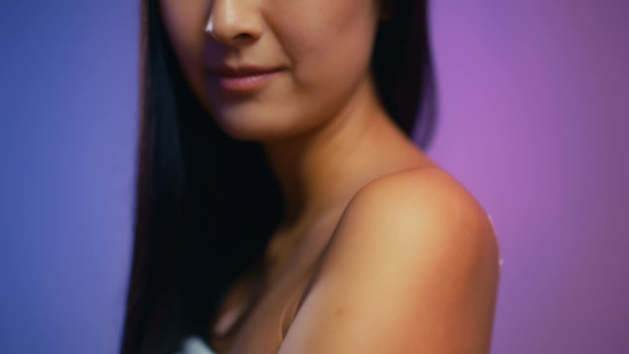 年轻女子露出肩膀，涂上了心形的防晒霜视频下载