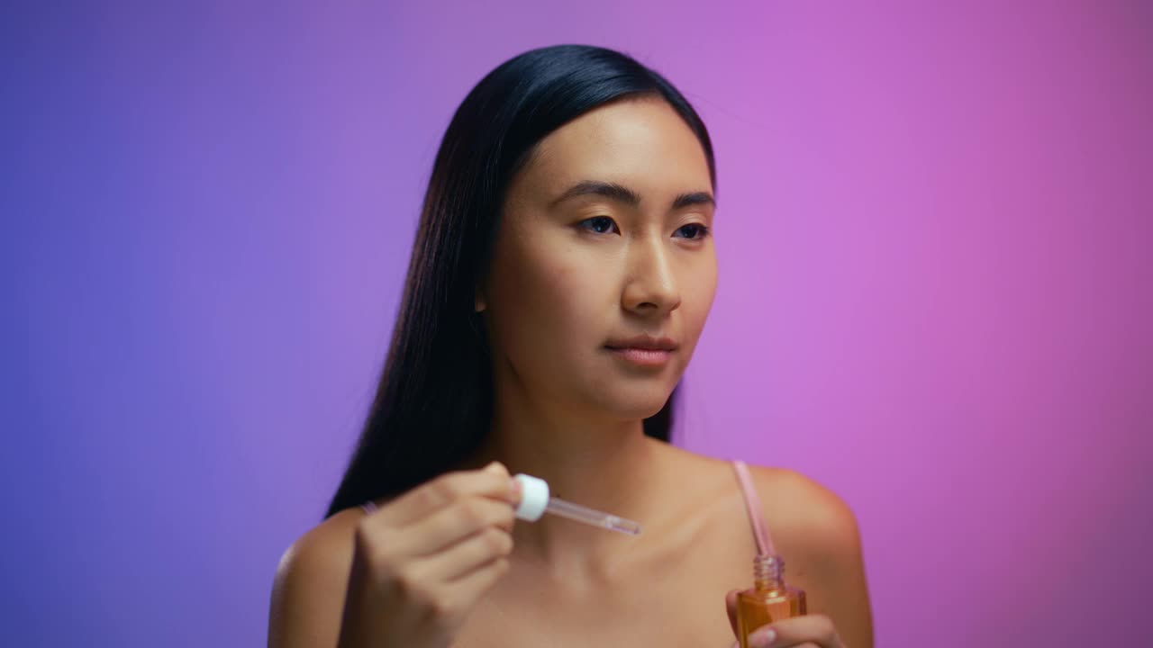 美丽的韩国女性使用视黄醇面部精华液，保湿，护肤视频下载