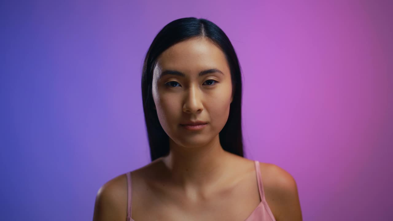 亚洲女性使用保湿面部精华液的肖像，积极的皮肤治疗视频下载
