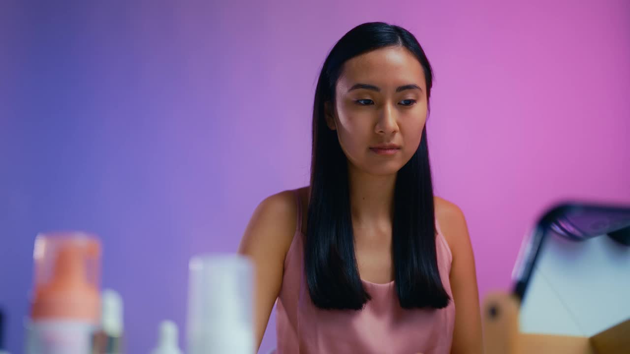 年轻的亚洲女人看着镜子，对自己的皮肤状况不满意视频下载