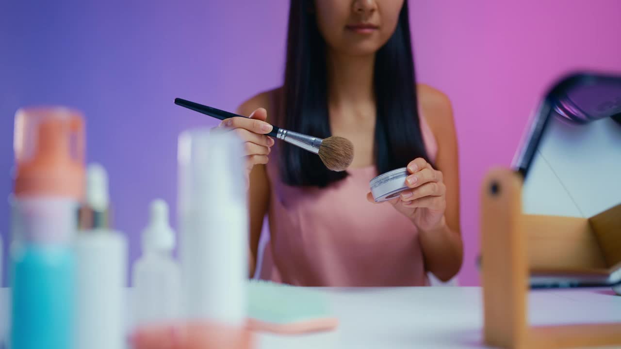 快乐的女人在镜子前涂粉，美容程序，化妆视频下载