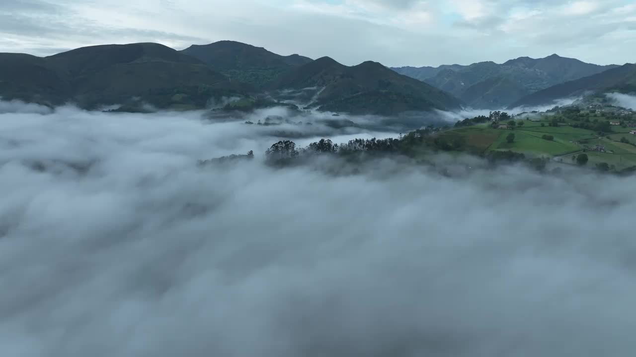 西班牙雾蒙蒙的山谷中，云雾笼罩的山脉和郁郁葱葱的绿色森林鸟瞰图。视频素材