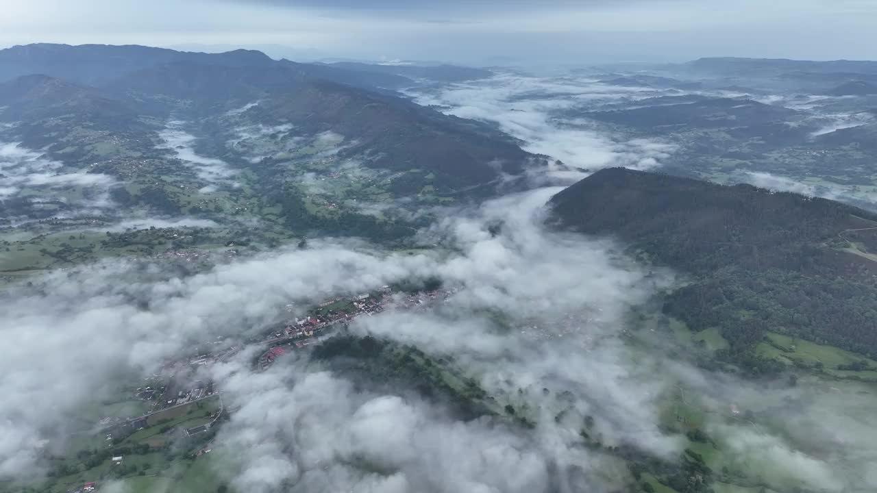 鸟瞰图在宁静的村庄薄雾山谷和茂密的森林，西班牙。视频素材