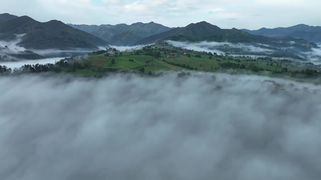 鸟瞰西班牙偏远山谷中雾蒙蒙的山脉和郁郁葱葱的绿色植物。视频素材