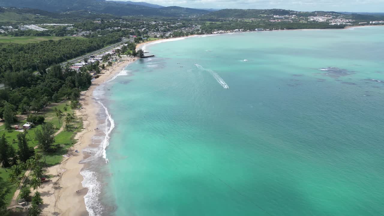 海浪冲击着波多黎各的沙滩(luquillo冲浪海岸海岸线)加勒比海旅游度假沙滩度假(棕榈树，山丘，亭子，空中无人机镜头)美丽的天堂风景视频素材