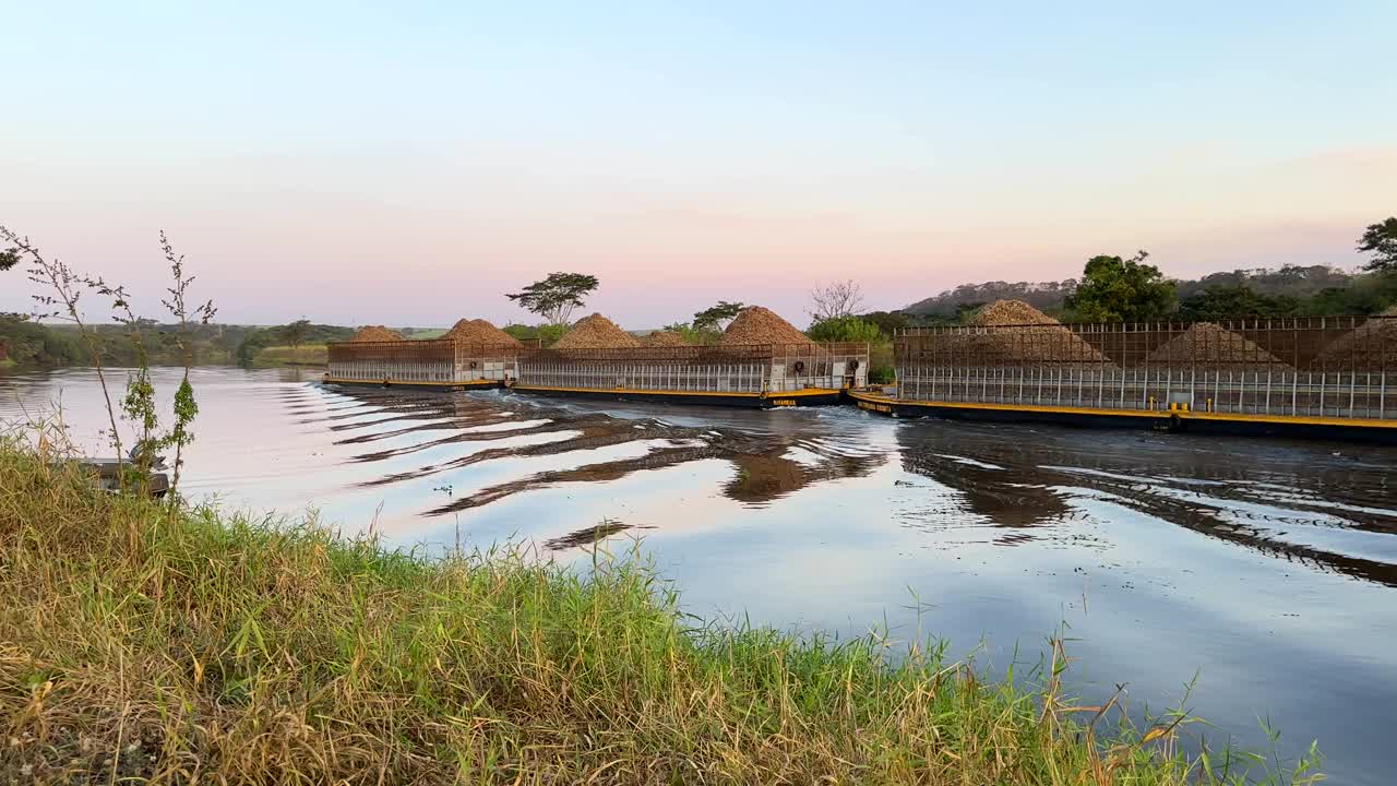 巴西圣保罗巴里里——2024年6月8日——运输甘蔗渣的船只通过铁特河水道视频下载