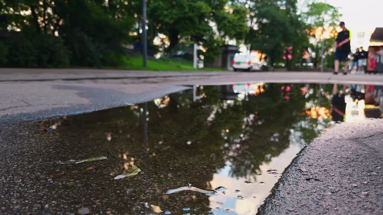 水坑中的城市倒影展现了城市中车辆和行人的活动，捕捉了日间风景中的城市生活精华视频素材