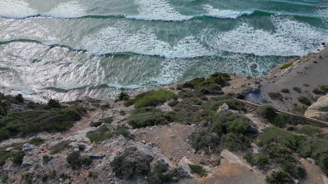 鸟瞰图，巴塞罗那吉尼斯塔港的岩石海岸线和海浪视频素材