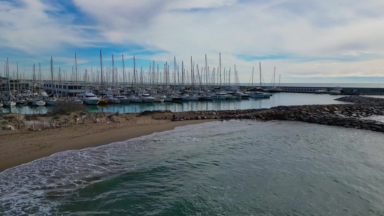 在多云的天气里，帆船停靠在巴塞罗那的海岸和吉内斯塔港视频素材