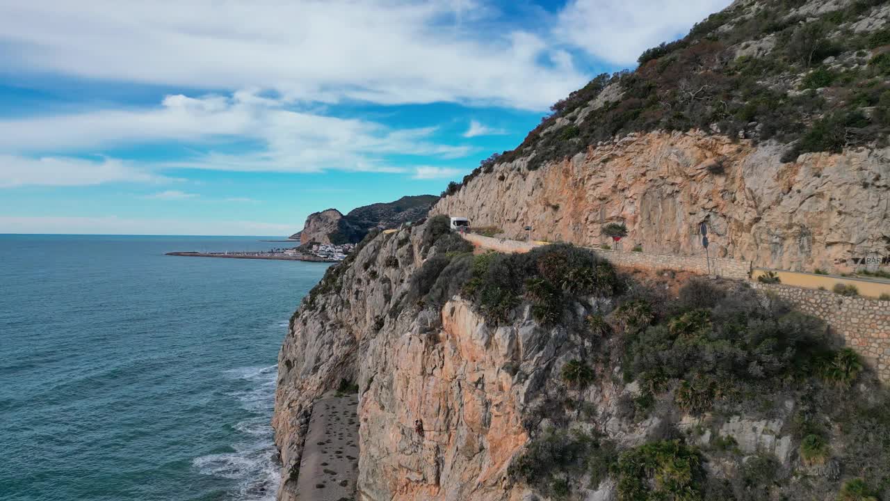 在巴塞罗那的吉内斯塔港，卡车沿着悬崖峭壁行驶在风景秀丽的海岸公路上，俯瞰着大海视频素材