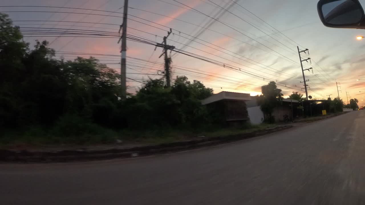 延时;清晨，一辆汽车在路上驶过房屋的侧视图。视频下载