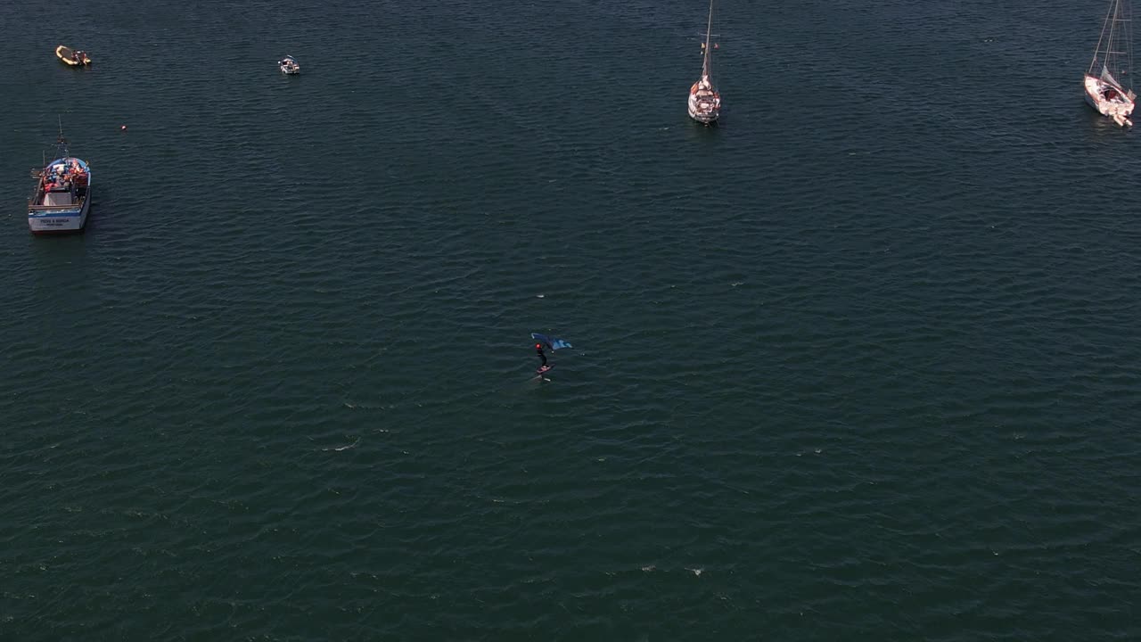 鸟瞰风筝板在海湾在一个阳光明媚的下午航行之间的船在卡斯凯伊斯，葡萄牙视频下载