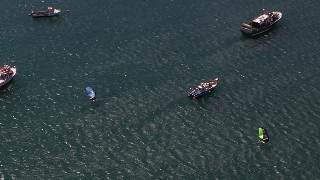 鸟瞰风筝板在海湾在一个阳光明媚的下午航行之间的船在卡斯凯伊斯，葡萄牙视频下载