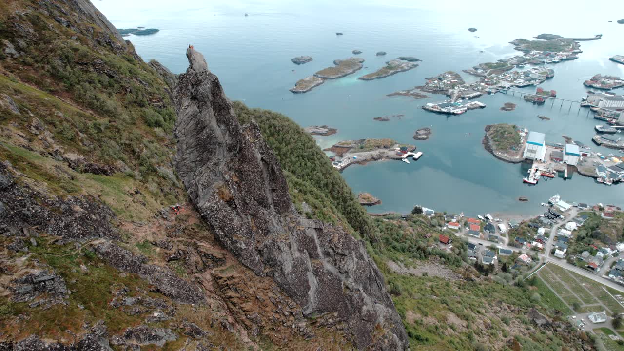 在轨道上鸟瞰Svolvaergeita(山羊)的岩石顶峰，人们在那里练习攀岩。在挪威的罗弗敦。视频素材