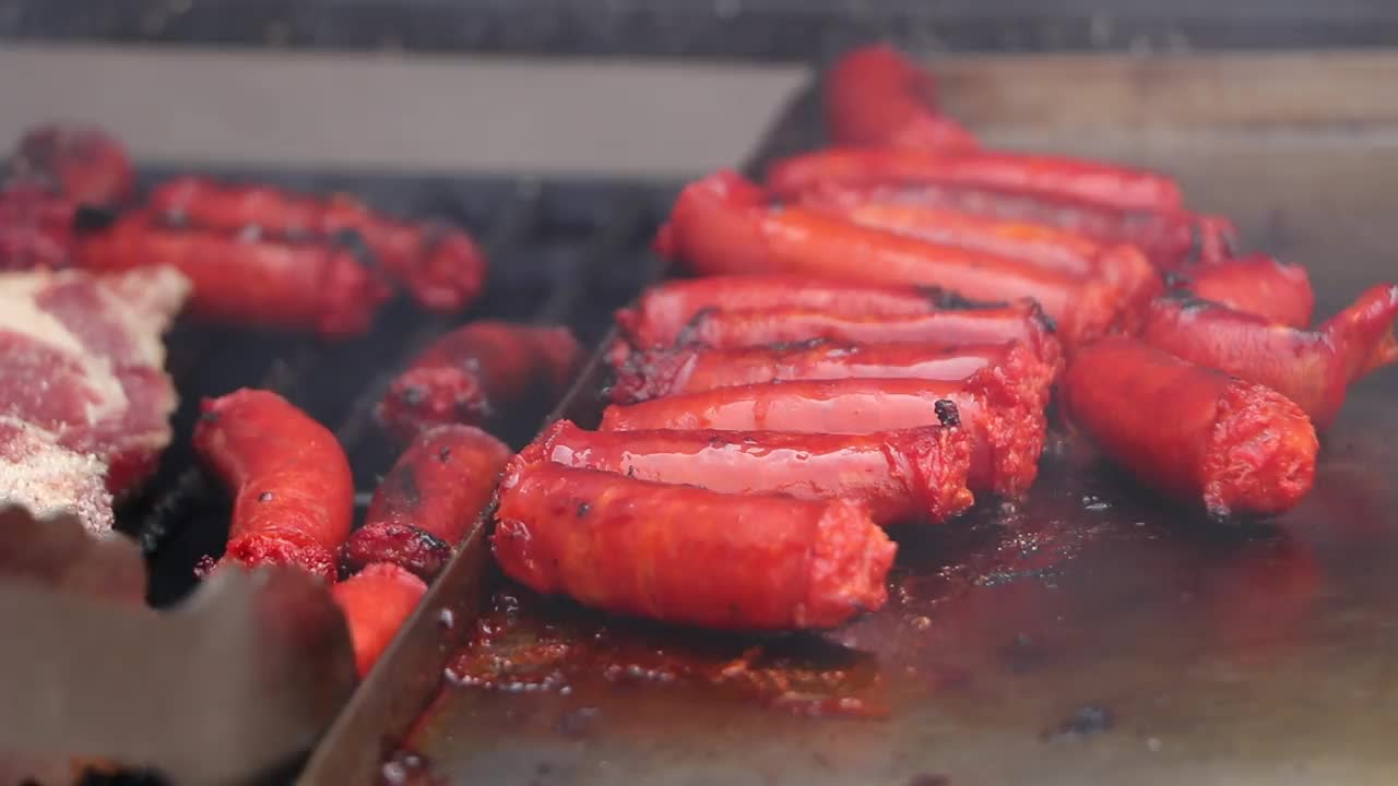 香肠在烤架上烹饪，然后翻面完成烹饪。视频下载