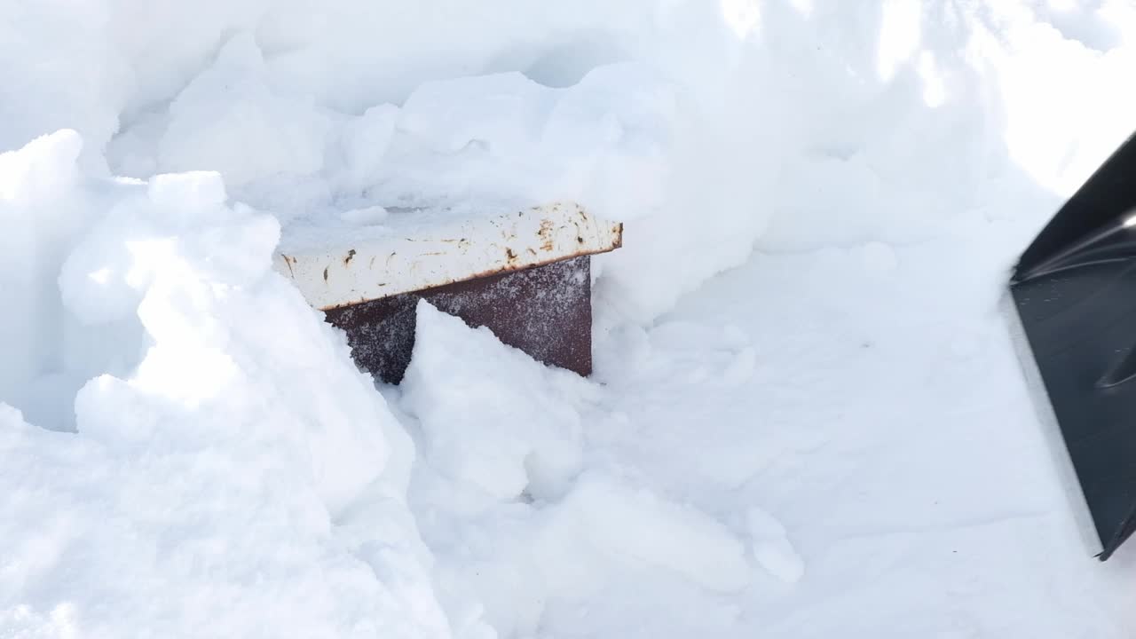 手拿雪铲在运动中清除白色的雪与模糊的运动和冬季背景视频下载