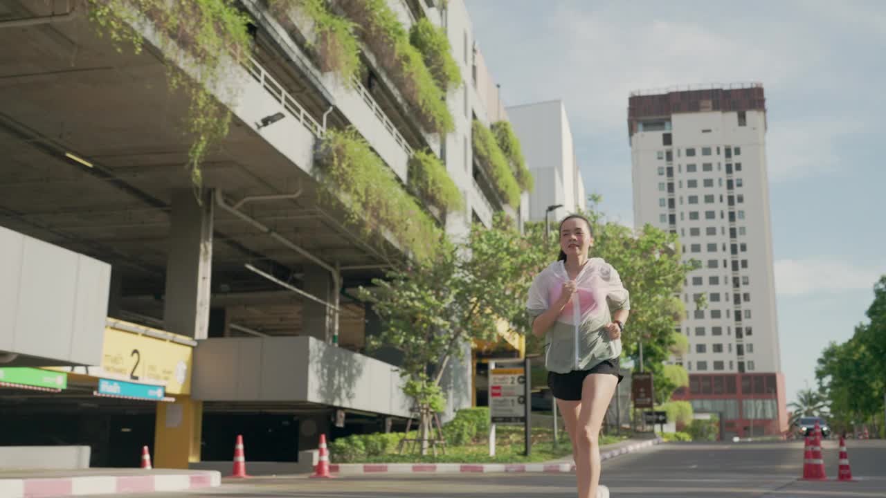 一个女人在一幢大楼前的街上跑着视频素材