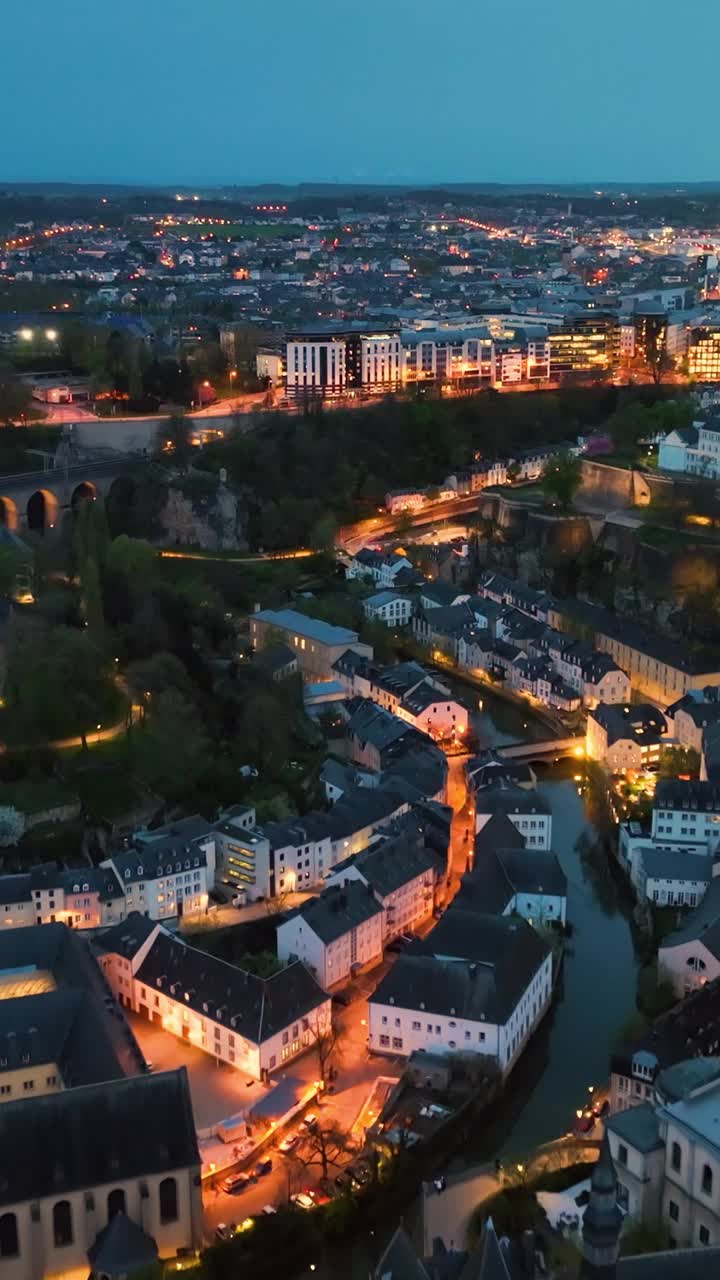 卢森堡大公国的垂直鸟瞰图，夜晚的城市天际线，沿着阿尔泽特河在卢森堡历史悠久的老城区视频素材