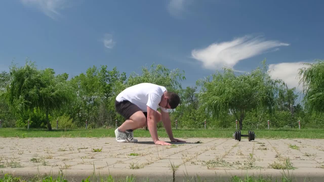 强壮的白人男子在公园里用壶铃锻炼视频素材