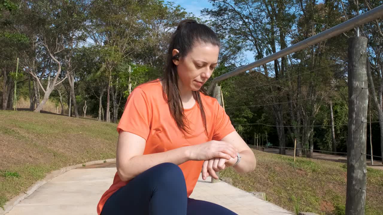 女人检查智能手机开始计划她的晨跑视频素材