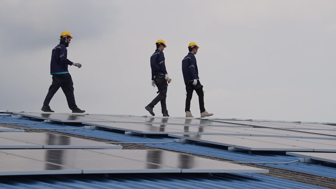 安装了太阳能电池的男工程师在工厂屋顶上行走。技术人员对系统结构进行检查和检查。工业可再生能源概念视频素材