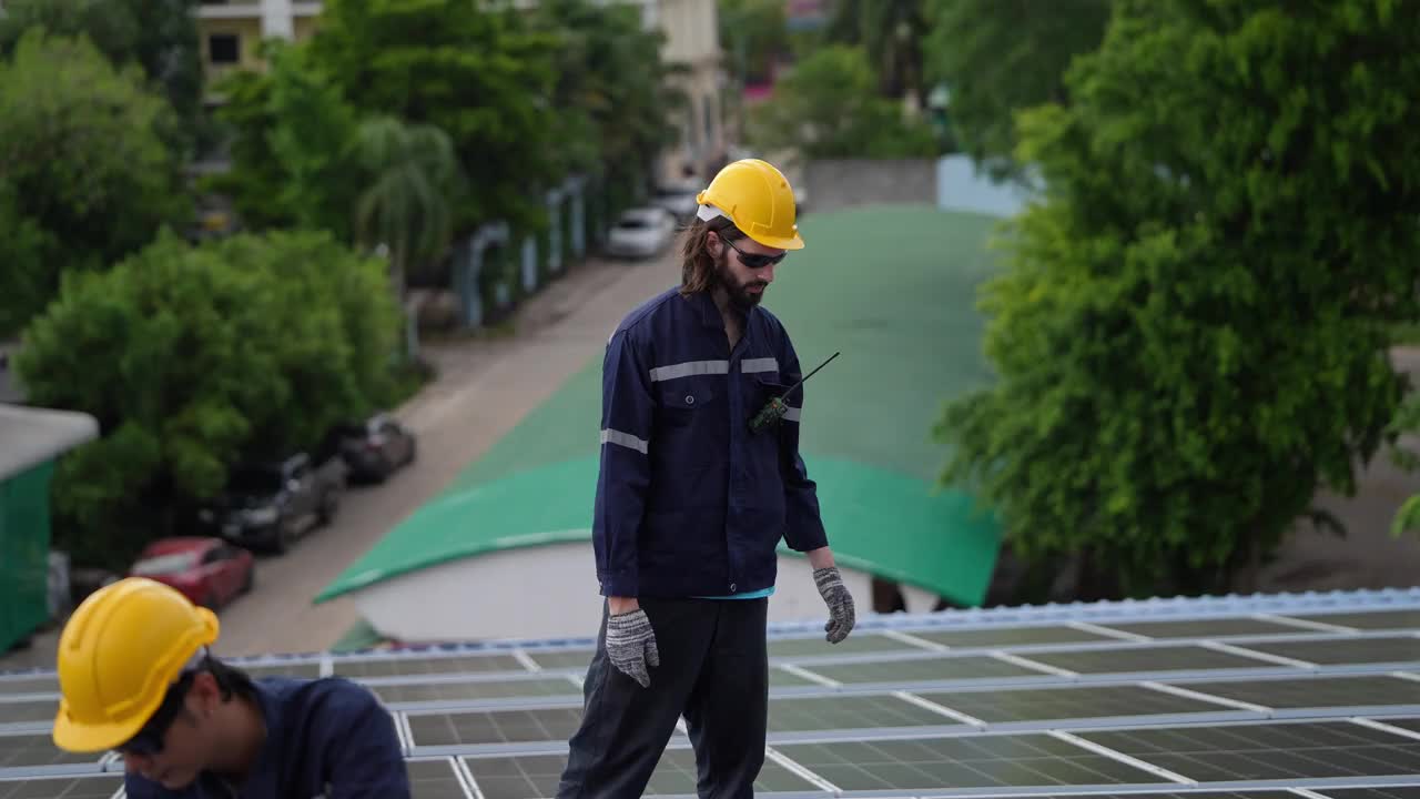 安装了太阳能电池的男工程师走在工厂的屋顶上。技术人员对系统结构进行检查和检查。工业可再生能源概念视频素材