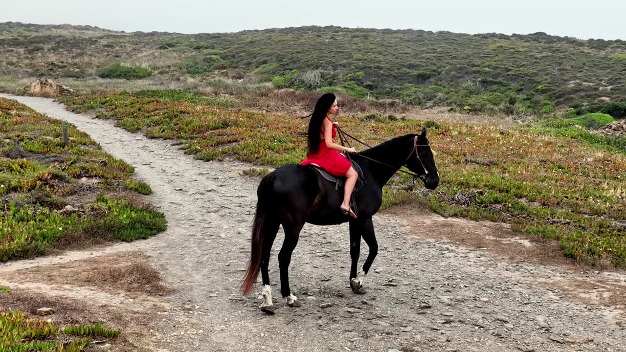 红衣女子骑马在文森特海岸步道视频素材