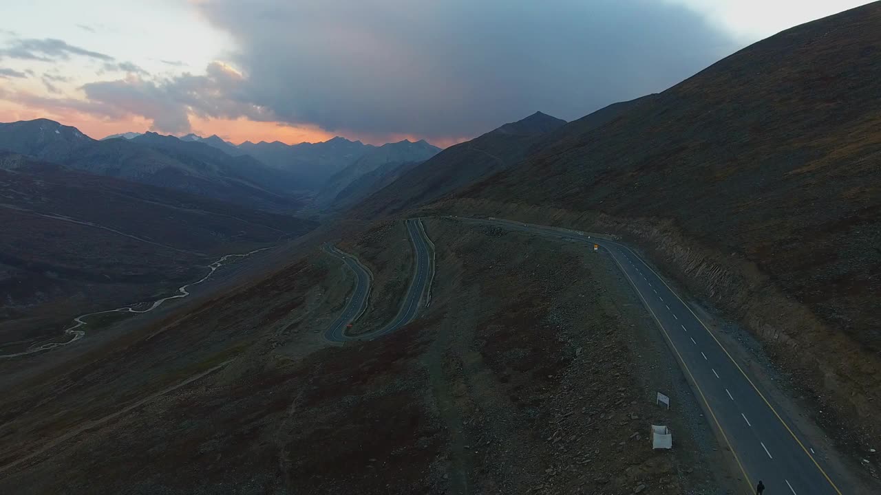 黄昏时分巴基斯坦巴布萨尔山口蜿蜒道路的鸟瞰图。视频素材