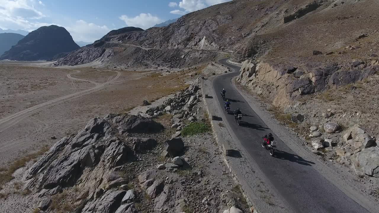 巴基斯坦，骑自行车的人在蜿蜒的道路上鸟瞰图。视频素材