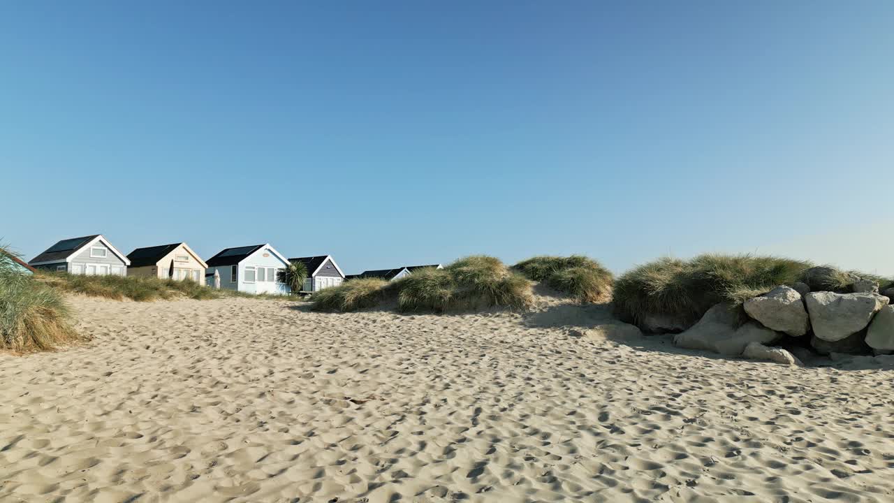 无人机在海滩小屋上空飞行，并在海滩和大海周围平移的4k视频视频素材